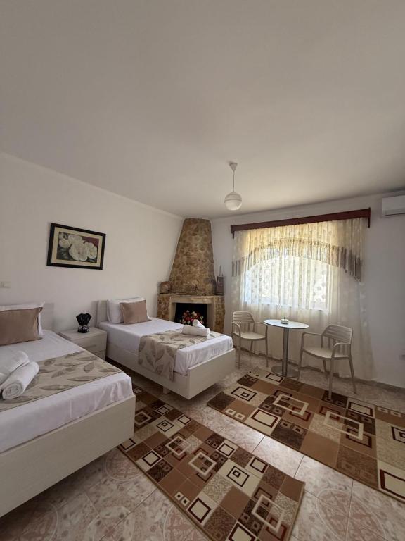a hotel room with two beds and a fireplace at Merkaj House in Berat