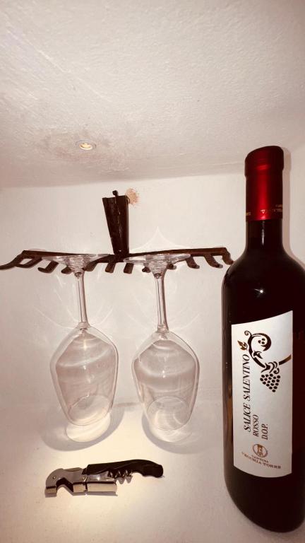a bottle of wine next to two wine glasses at Dal Nadìr allo Zènit room in Polignano a Mare