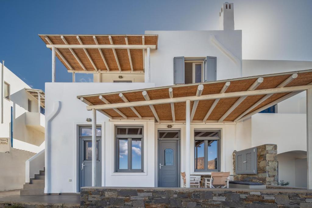 a white house with a wooden pergola at Rada Residence in Livadi