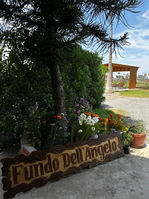 a sign that reads findado delaminado in front of flowers at Club Positano Fundo Dell'Angelo in Mala