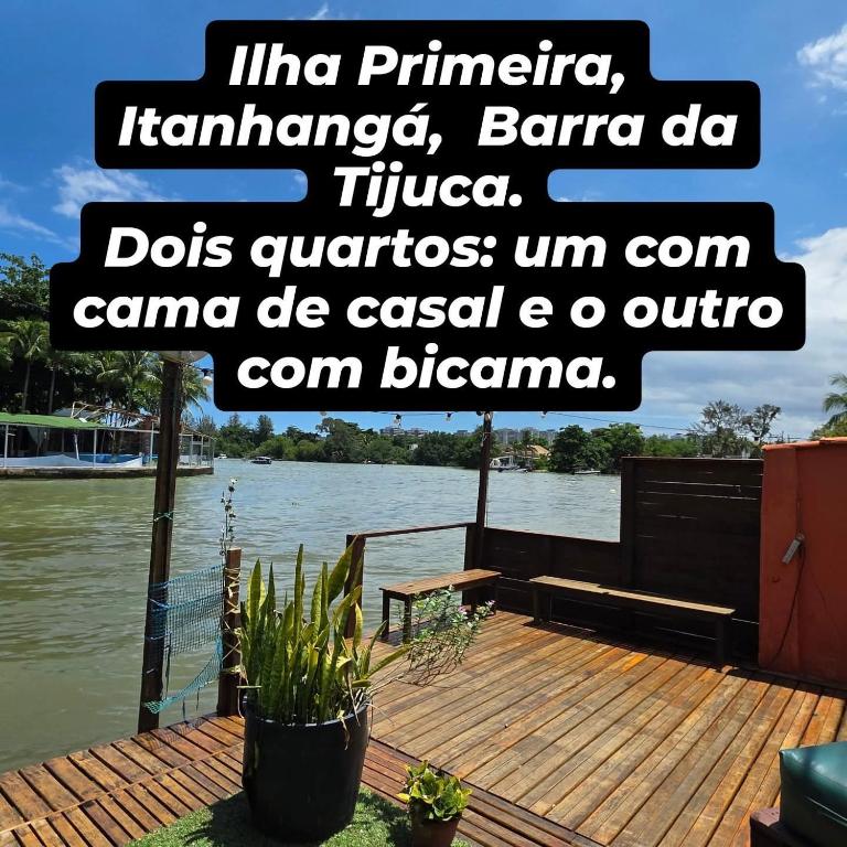 a sign on a dock with a view of a river at Recanto do Capitão in Rio de Janeiro