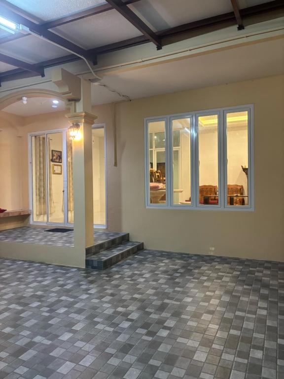 an empty room with a pillar and windows at Baan Kru Ju Single Room in Phuket
