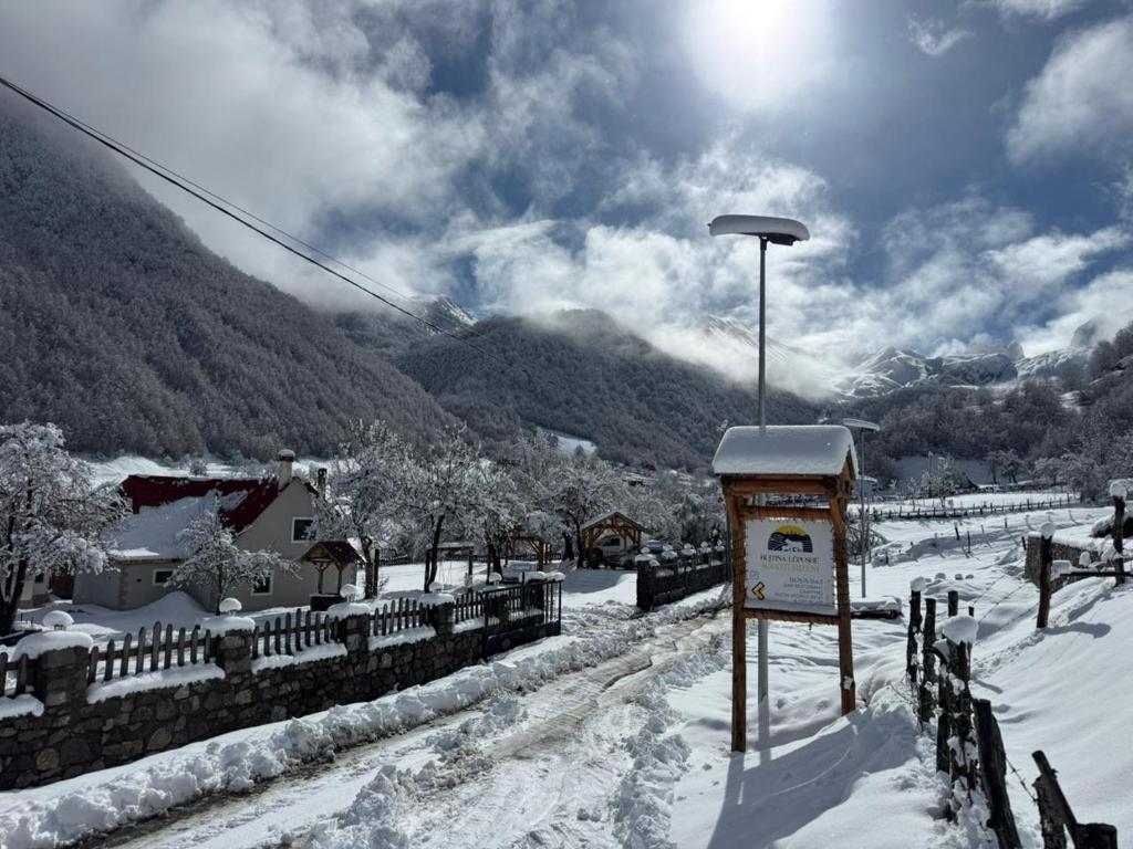 a sign in the snow next to a fence at Bujtina Lepushe Agroturizem in Lëpushë