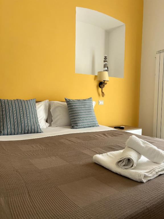 a bedroom with a large bed with yellow walls at Mare guest house in Termoli
