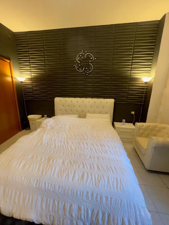 a large white bed in a room with a window at private room in a shared apartment in Seveso