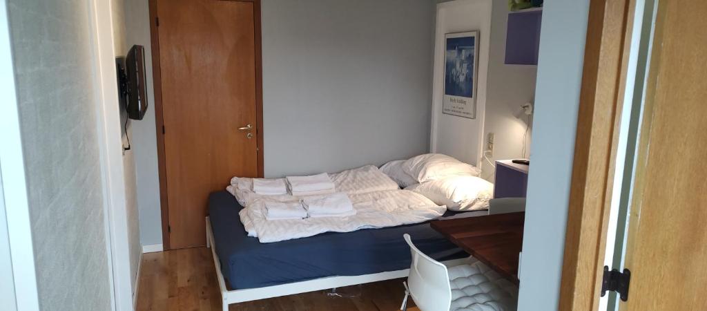 a small room with a bed with towels on it at Central Microflat, free parking, garden BBQ, LegoHouse, Legoland, in Billund