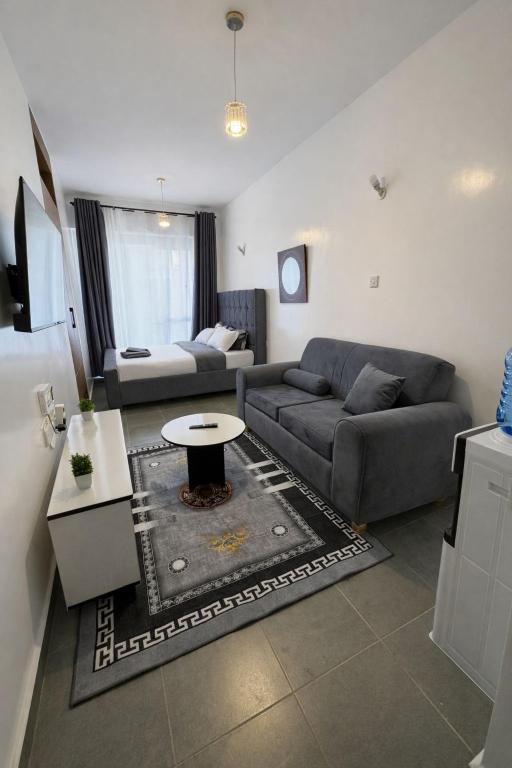 a living room with a couch and a table at The Cozy Cube at Tsavo Sunset in Nairobi
