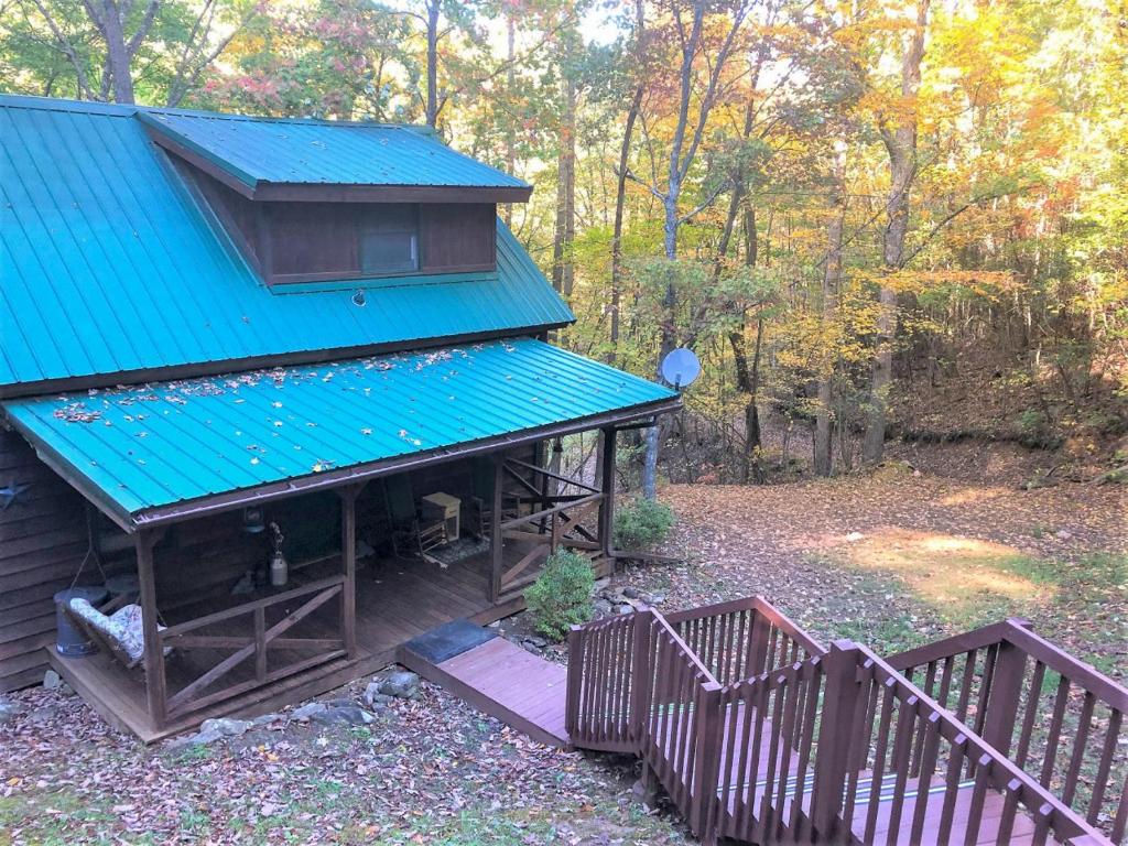 a cabin with a blue roof in the woods at Ducks Nest Retreat- Close to Ocoee river in Turtletown