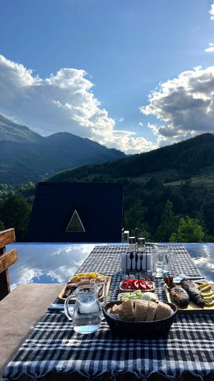 a picnic table with food on a checkered table cloth at Pjesnikova Dolina in Mojkovac