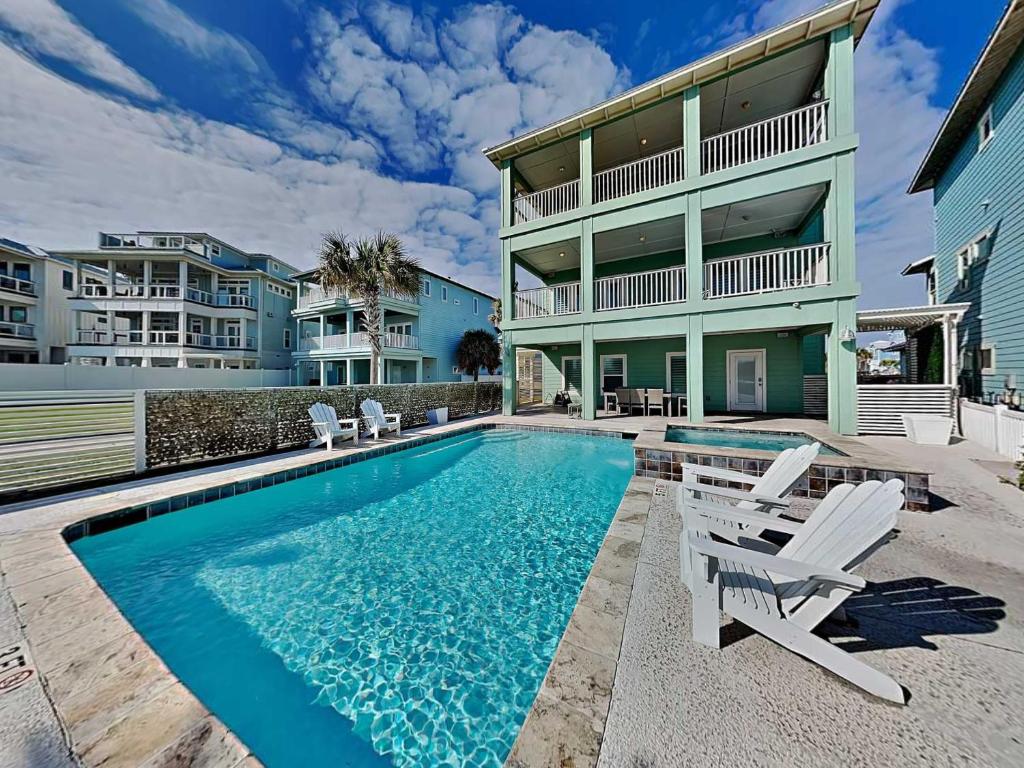 a swimming pool in front of a house at All Decked Out in Padre Island