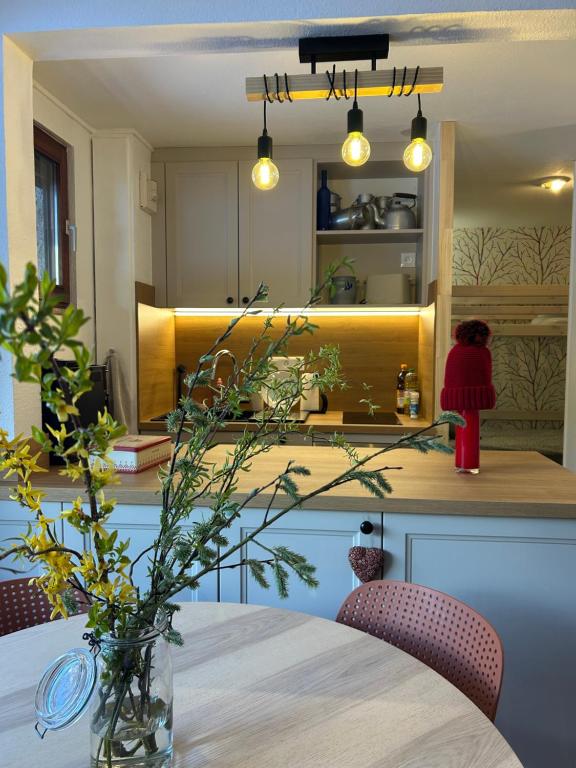 a kitchen with a table with a vase on it at Le Charme du Gaschney in Muhlbach-sur-Munster