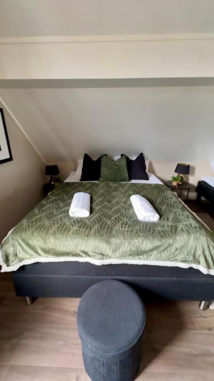 a bedroom with a large bed with a green comforter at Villa Utsikten Romsdalshorn in Åndalsnes