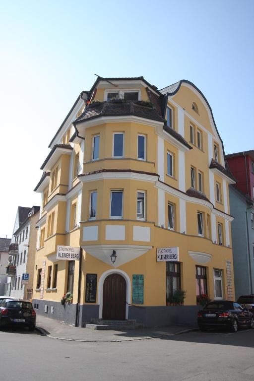 un bâtiment jaune sur le côté d'une rue dans l'établissement Stadthotel Kleiner Berg, à Friedrichshafen