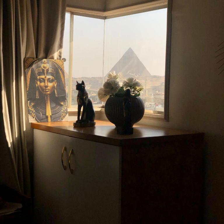 a desk with a window with a statue of the egyptianaraoh at Rafifi pyramids inn view in Cairo
