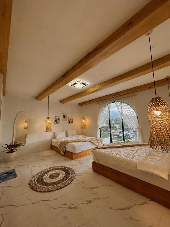 a bedroom with two beds and a large window at Kizuna villa in Diyeng
