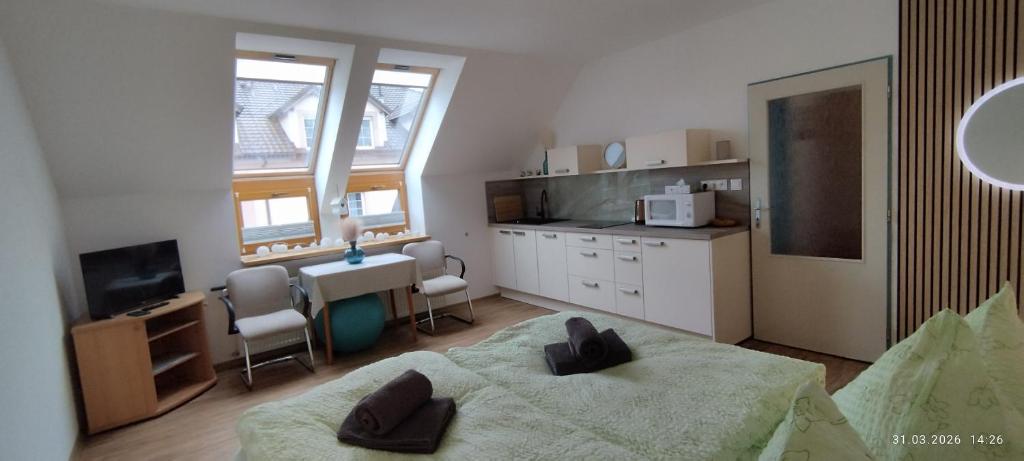 a bedroom with a bed and a table and a kitchen at Apartment Bertík in Třeboň