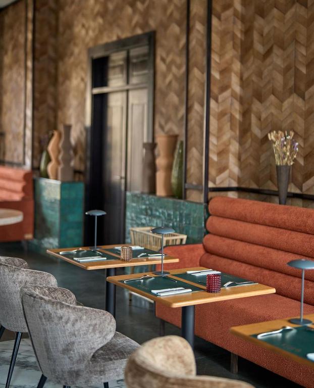 a dining room with two tables and chairs at KÓLÒ Hôtel in Yaoundé