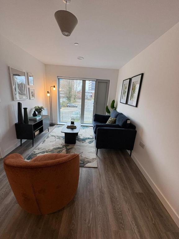 a living room with a couch and a chair at Stylish 2 bedroom modern apartment central to Eccles in Manchester