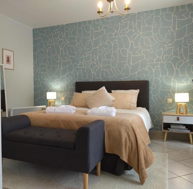a bedroom with a bed with a blue wall at Fleurs de Cosmos, suite lumineuse climatisée in Albi