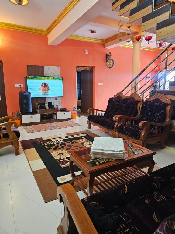a living room filled with furniture and a flat screen tv at Kalon Elpis Villa in Ooty