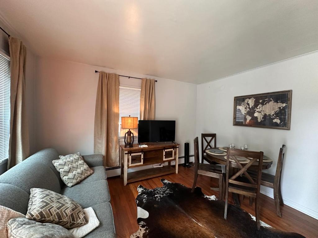 a living room with a couch and a table and a television at Pets Welcome Walkable Downtown Apt Gym & Pool Pass in Sheridan