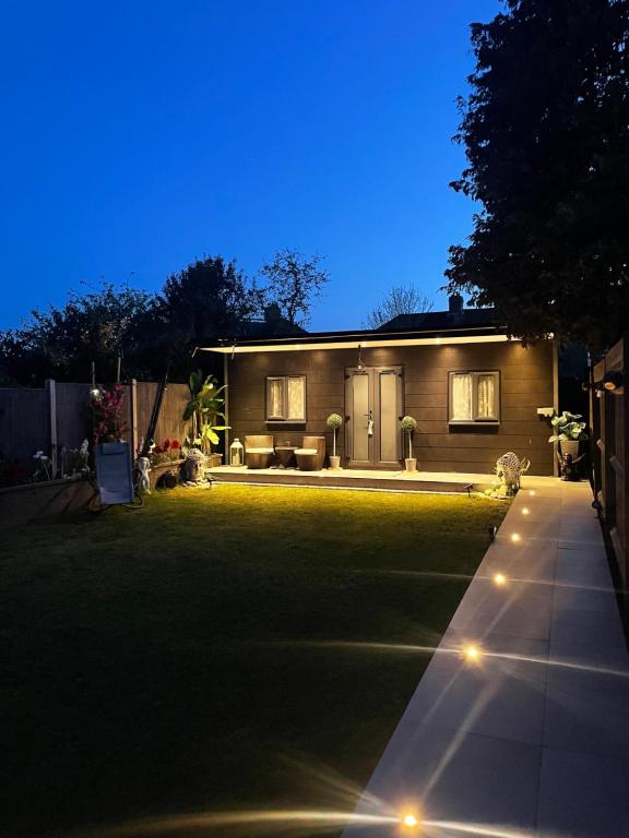 a house with a lawn in front of it at night at Family cottage in Epsom
