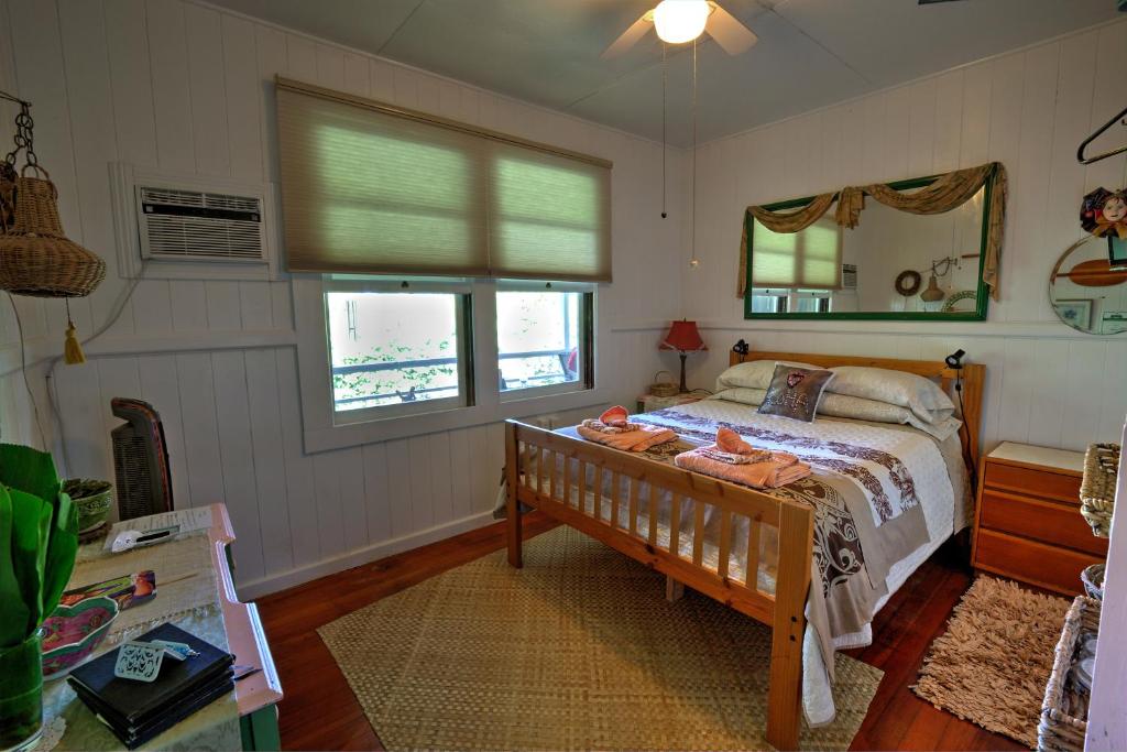 a bedroom with a bed and a mirror at Hale Kawehi Guesthouse in Hilo