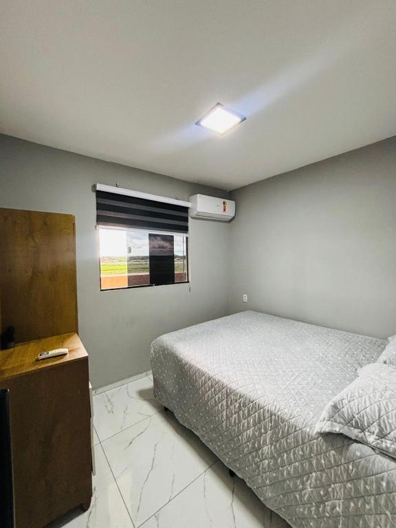 a bedroom with a bed and a window at Flats Sucesso in Teresina
