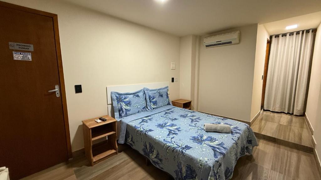 a bedroom with a bed with a blue bedspread at Caminho de Itacoatiara in Niterói