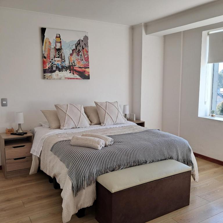 a bedroom with a bed with a picture on the wall at Departamento Los Carrera Centro in Osorno