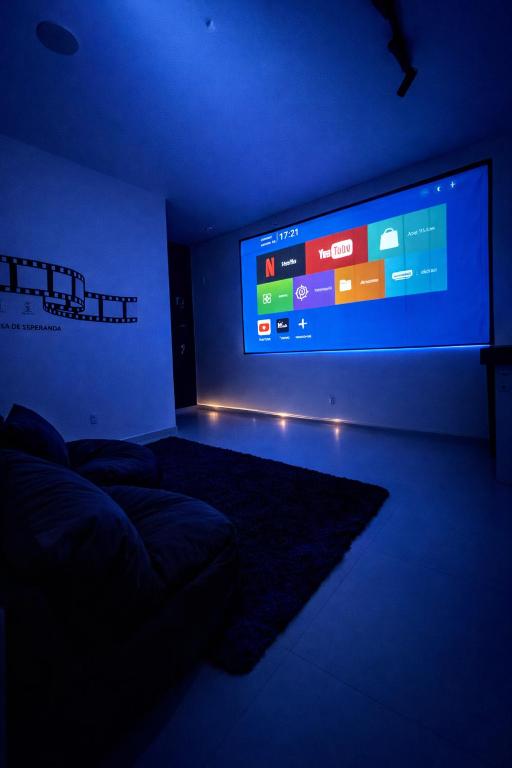 a room with a large screen in a dark room at Flats Temáticos - By Temporada Expert - Conforto e Climatizado in Feira de Santana