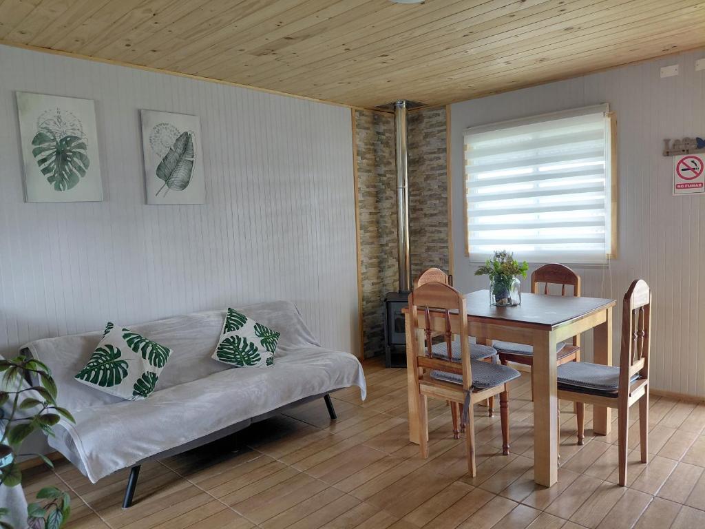 a living room with a couch and a table at Cabaña Aeropuerto el Tepual in Puerto Montt