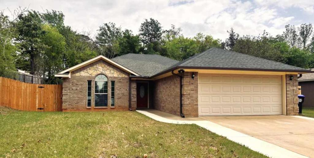 a brick house with a garage in a yard at Mendoza Villa - Longview Tx in Longview