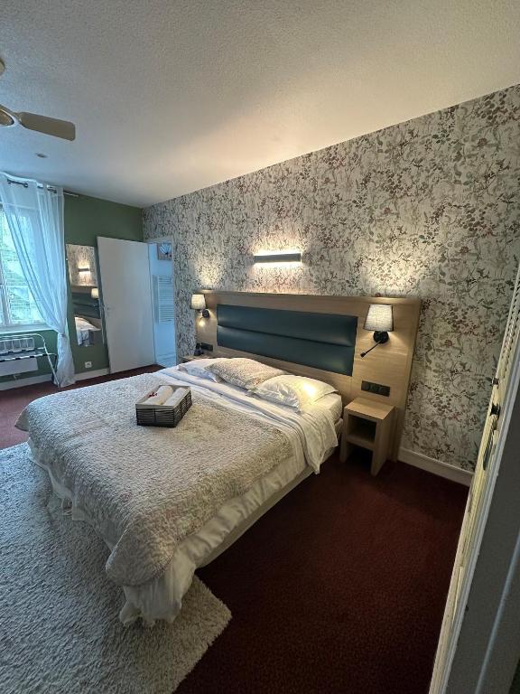 a bedroom with a large bed in a room at Logis Hôtel Restaurant bistronomique La Vieille Auberge, in Souillac