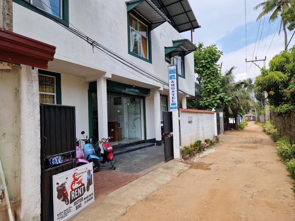 a building with two scooters parked outside of it at Wings Hotel & Hostel in Trincomalee