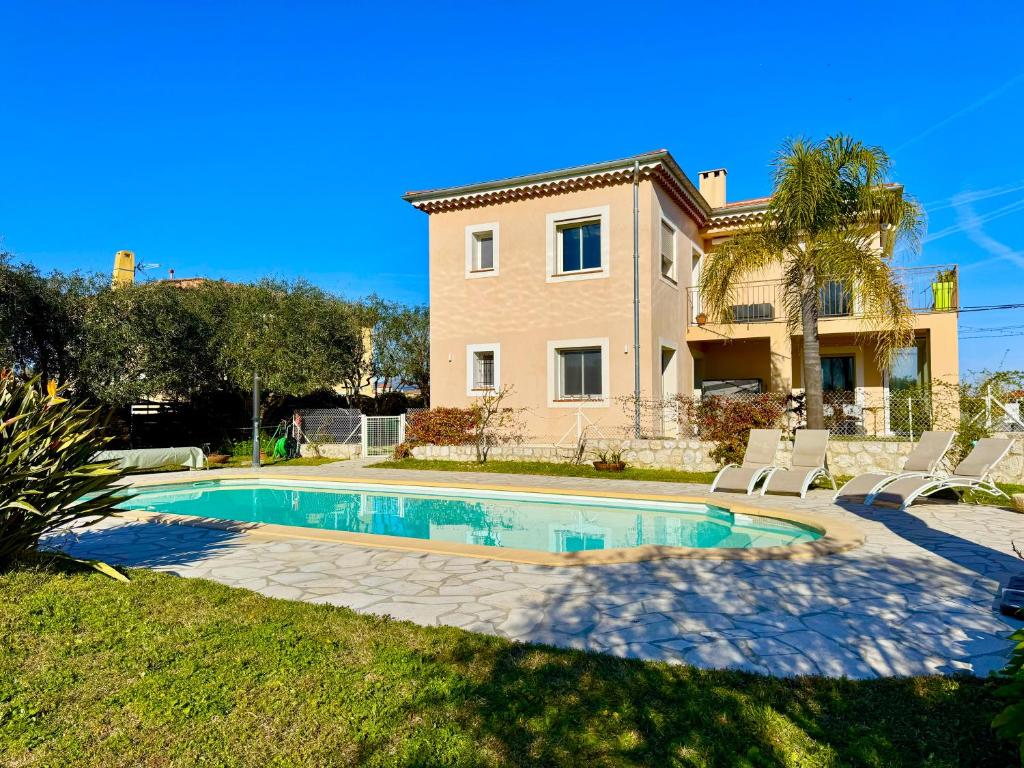 a villa with a swimming pool in front of a house at Villa SYAGRUS - Easy Home Booking in Nice