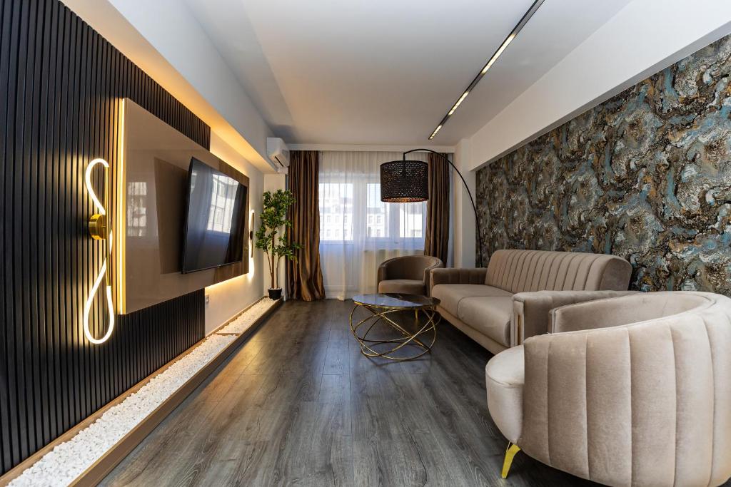 a living room with couches and a tv on a wall at Old Town Luxury 1 in Târgovişte