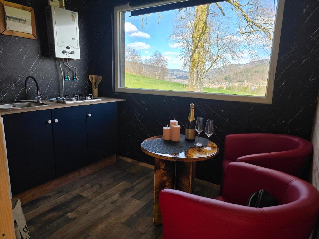 a kitchen with a table and two chairs and a window at Le Nid Douillet du Tacot in Le Thillot