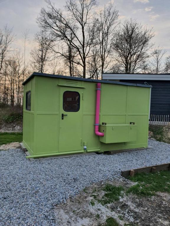 a green trailer sitting on a gravel field at De Wachtloper in Bant