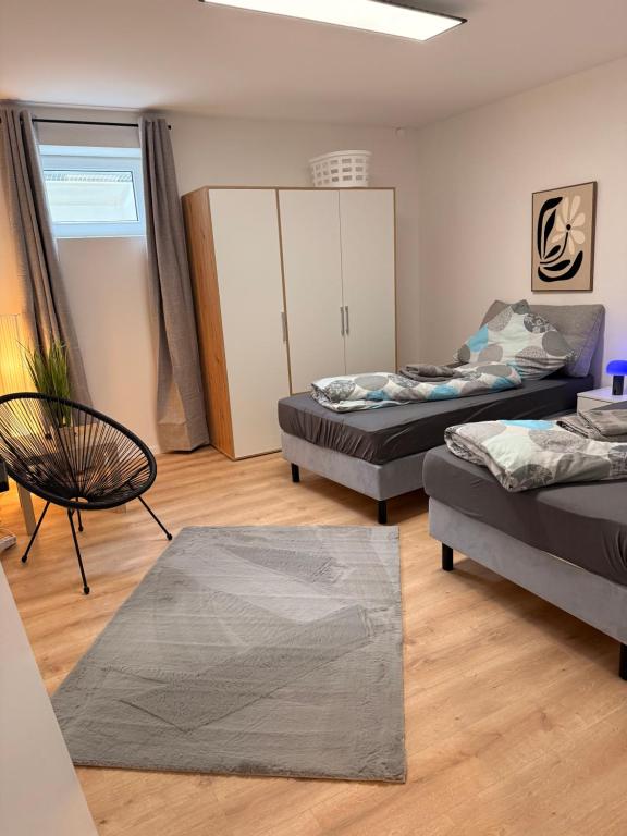 a room with two beds and a chair and a cabinet at Casa Daniela Residence in Vilshofen an der Donau
