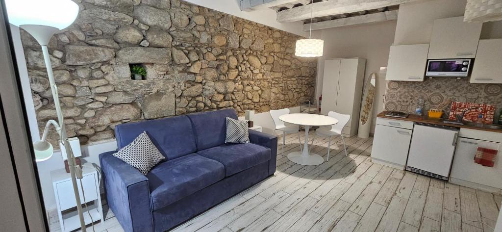 a living room with a blue couch and a stone wall at Blue Living-Borgo Antico in Marciana Marina