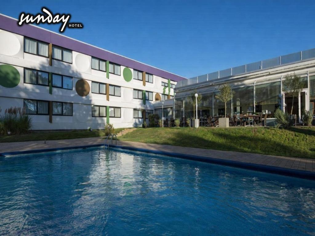 a swimming pool in front of a building at Sunday Saarbruecken Sued Standard Room in Saarbrücken