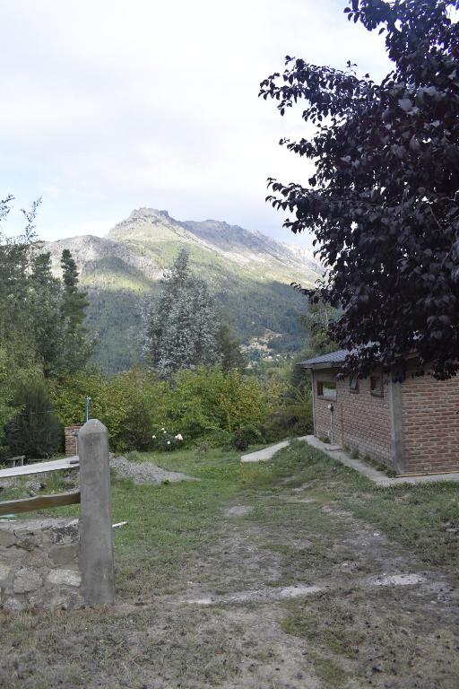 a view of a building with mountains in the background at Camping El Paraíso in El Hoyo