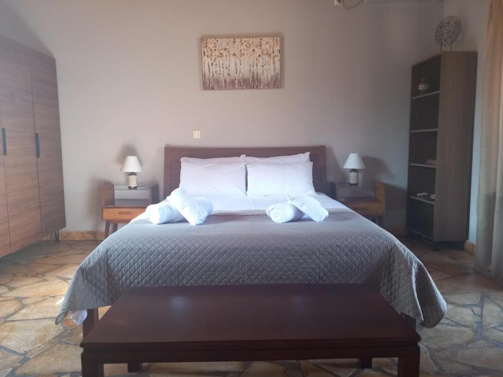 a bedroom with a large bed with two night stands at Epicurus beach cottage in Kánalos
