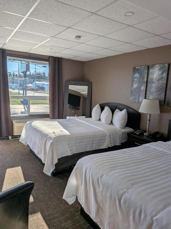 a hotel room with two beds and a large window at Beaver Motel in Wawa