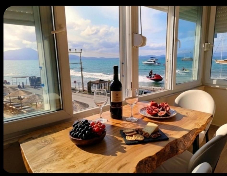 a table with a bottle of wine and wine glasses at AFİFE Apart, Kusadasi,Denize ve Plaja Sıfır in Kuşadası