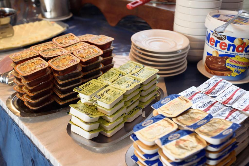 a bunch of food on a table with plates at Hotel Porto Perissa in Perissa