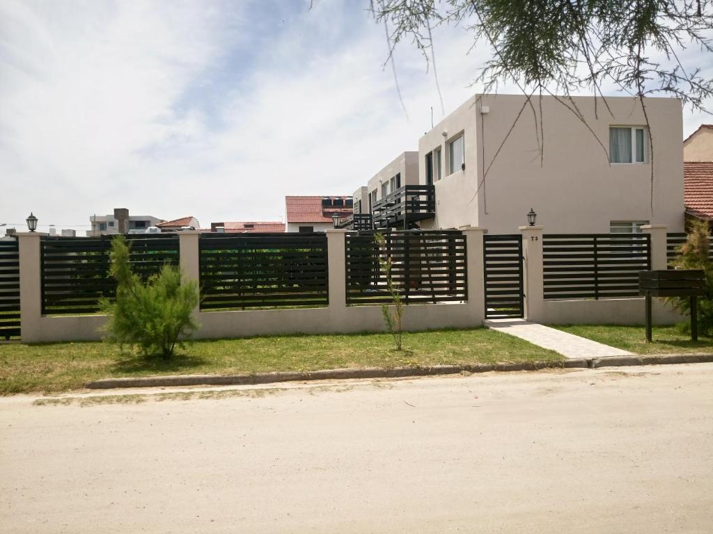 una cerca frente a una casa en Departamentos Los Tamariscos en Santa Clara del Mar