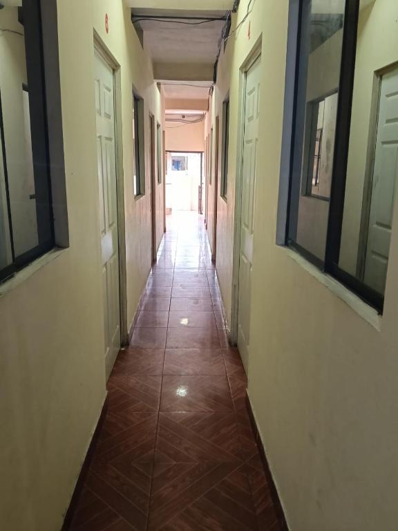 an empty hallway with doors and a tile floor at Casa Hotel Lunita in Iquitos
