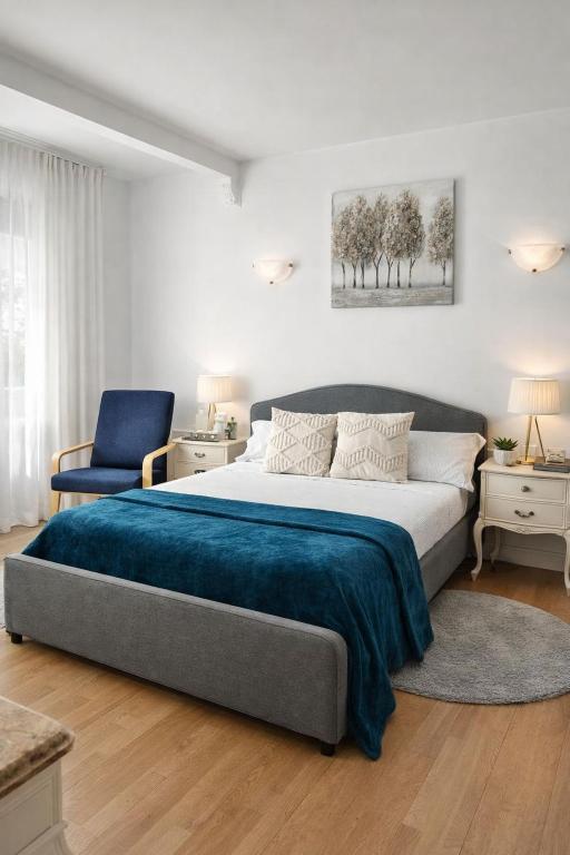 a bedroom with a large bed and a blue chair at Luxury Double Room Marbella Center in Marbella